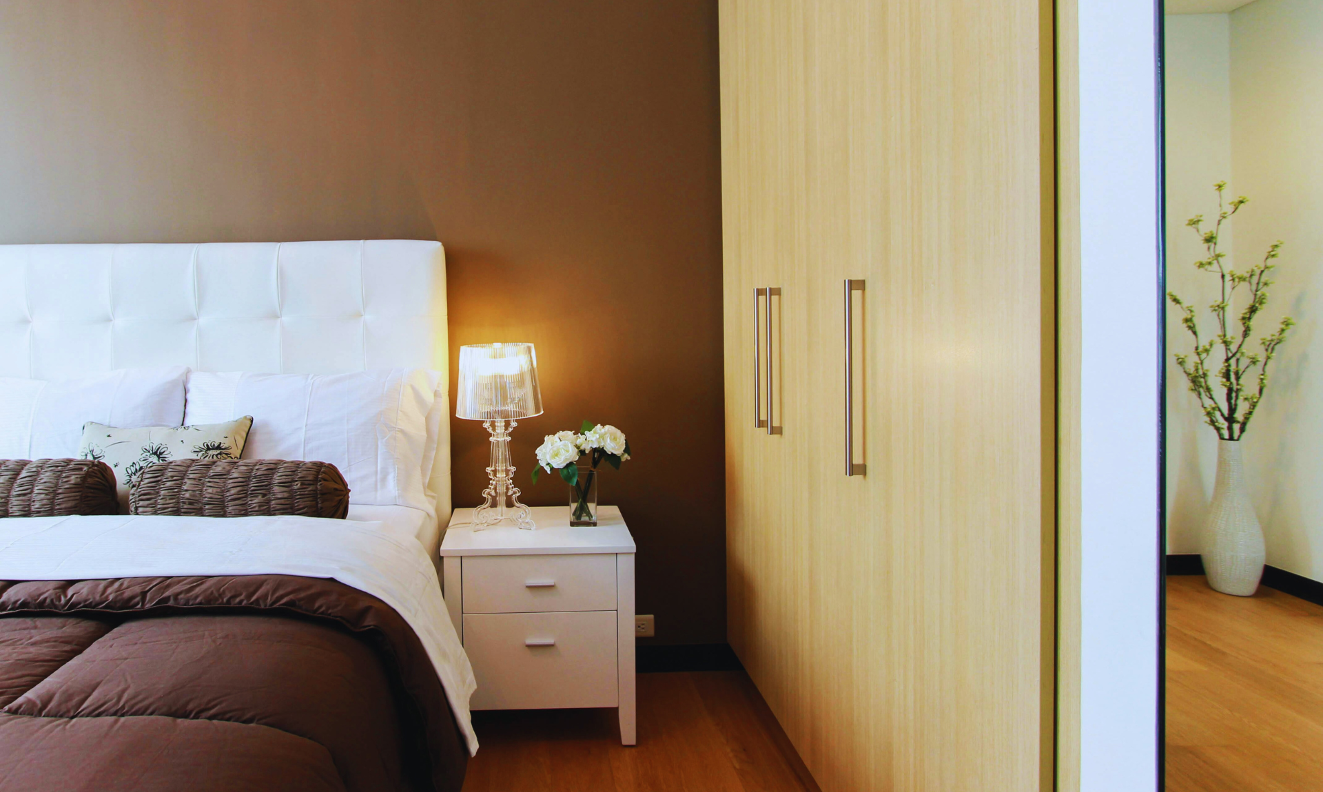 A bedroom decorated with mirrors and floating shelves
