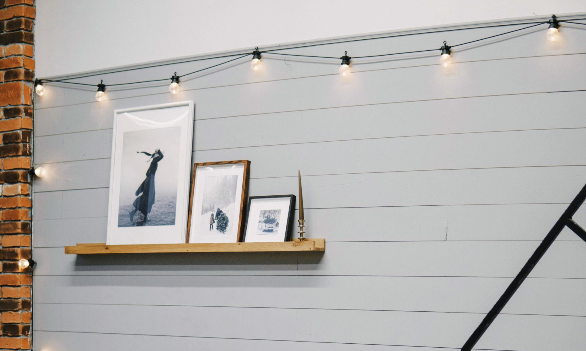 decorative floating shelves styled with books, candles and plants for an empty bedroom wall