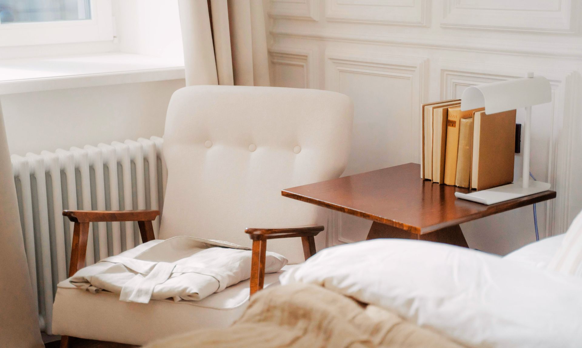 cozy reading corner in a small bedroom with armchair, warm lamp and side table